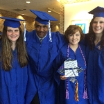 Four graduates in cap and gown